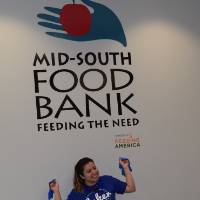 Photo of student posing in front of Food Bank Sign from Service Project